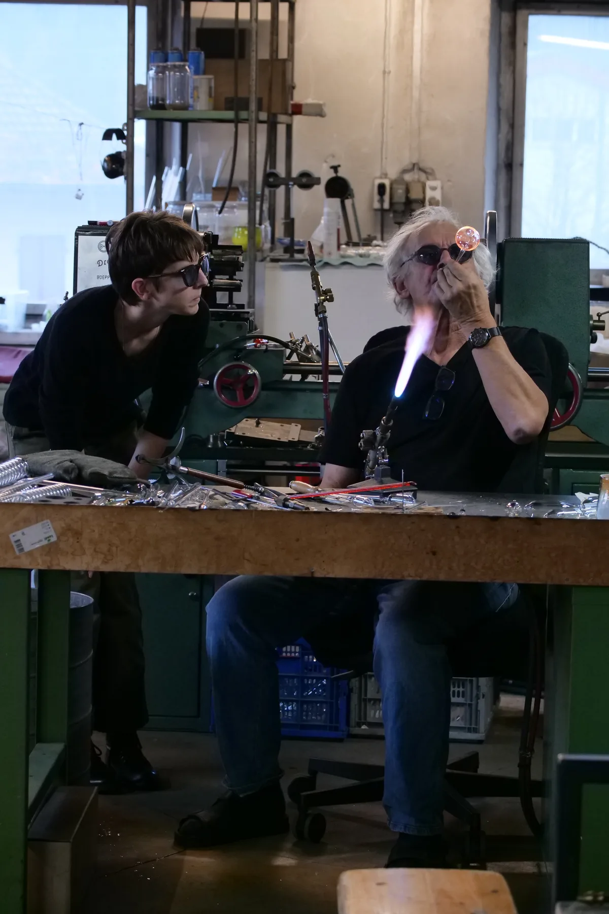 René Burri zeigt, wie man eine Glaskugel bläst. René Burri in seiner Glasbläserei in Wila.